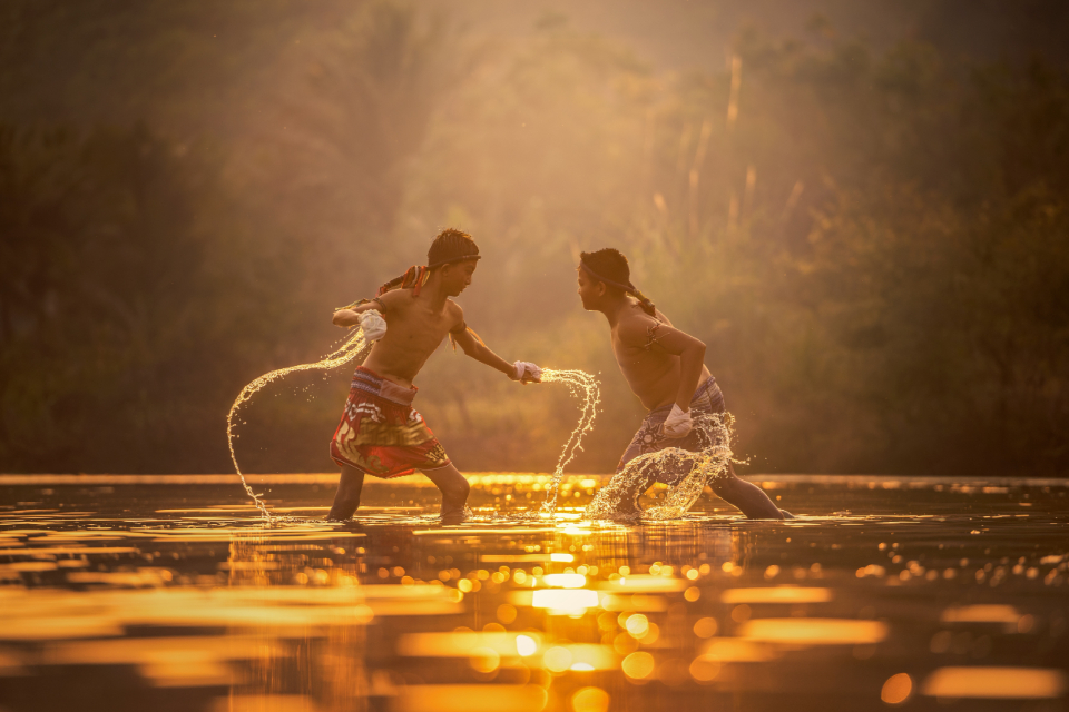 Two fighters training Muay Thai at sunset